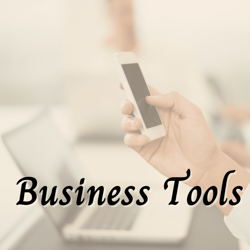 Photo of person's hand holding a smart phone with an open laptop in background, text "business tools" overlaid at bottom of photo